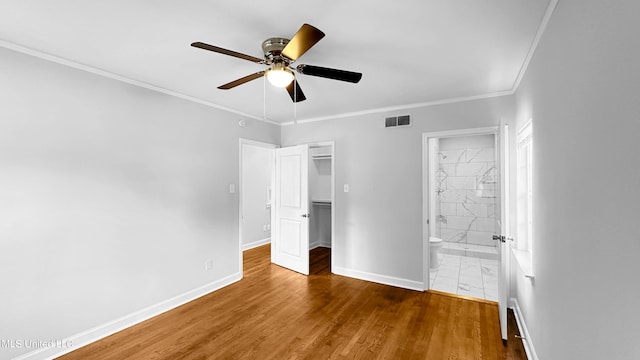 unfurnished bedroom with ceiling fan, dark hardwood / wood-style floors, connected bathroom, and ornamental molding