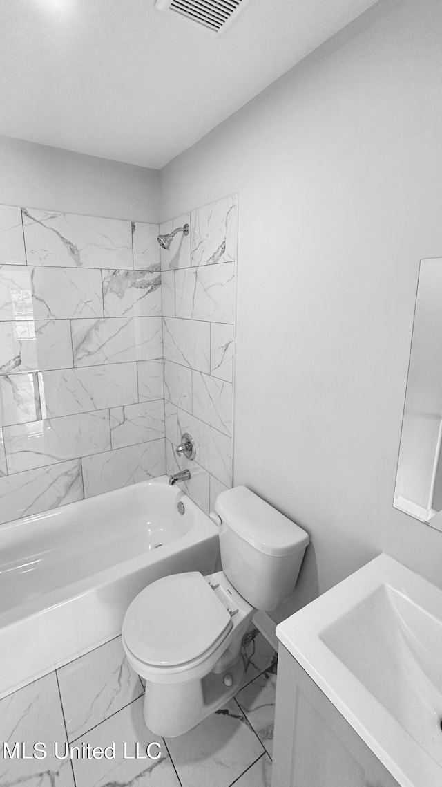 full bathroom featuring vanity, tiled shower / bath, and toilet