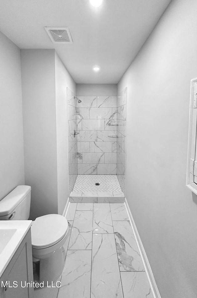 1049 Idlewild St, Memphis, TN 38107 - full bathroom with baseboards, marble look tile flooring, toilet, a tile shower, and vanity