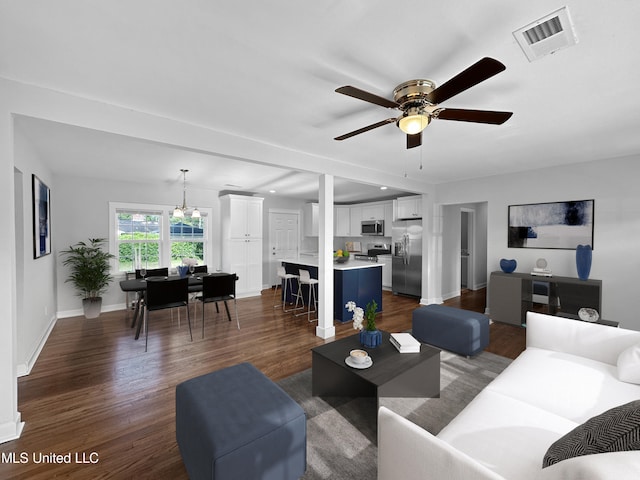 living room with ceiling fan and dark hardwood / wood-style flooring