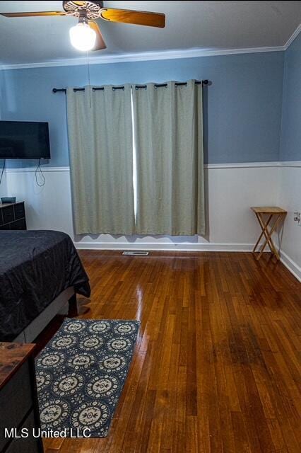 733 S College St, Grenada, MS 38901 - bedroom featuring wood-type flooring, a wainscoted wall, a ceiling fan, and ornamental molding