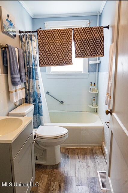 733 S College St, Grenada, MS 38901 - full bathroom with wood finished floors, ornamental molding, toilet, vanity, and shower / tub combo with curtain