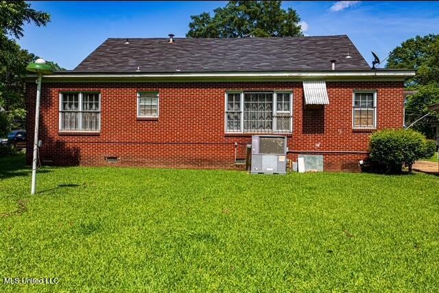 733 S College St, Grenada, MS 38901 - rear view of house featuring crawl space, a yard, brick siding, and central air condition unit