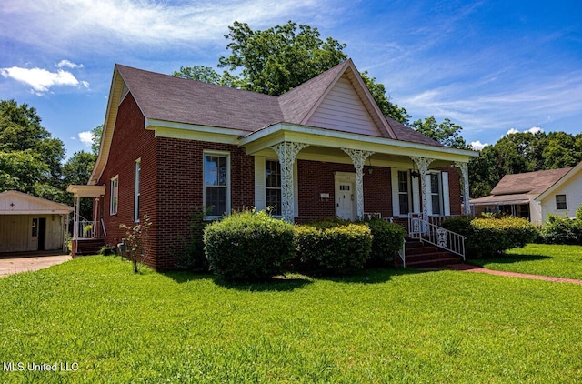 733 S College St, Grenada, MS 38901 - view of front facade with brick siding, a front lawn, a porch, and an outbuilding