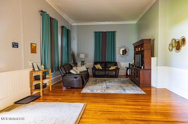 733 S College St, Grenada, MS 38901 - living area featuring wood finished floors, ornamental molding, and a wainscoted wall