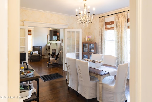 dining area featuring a chandelier, dark wood-type flooring, and ornamental molding