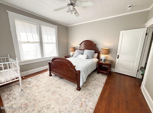 bedroom featuring dark hardwood / wood-style flooring, ceiling fan, and crown molding