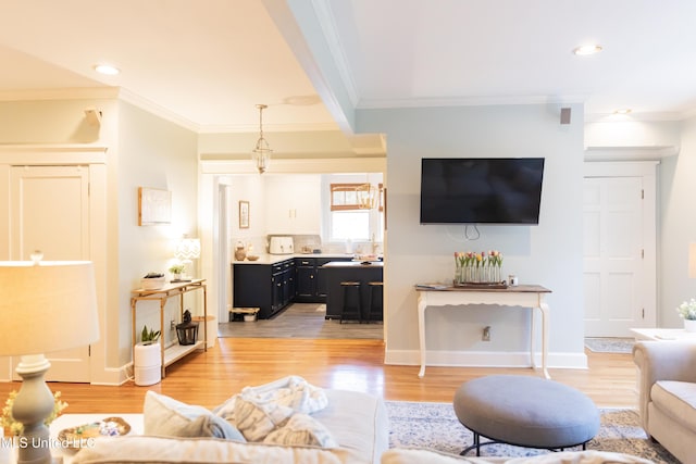 living room with light wood-type flooring and ornamental molding