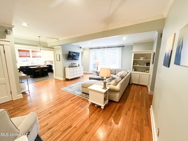 living room with light wood-type flooring and ornamental molding