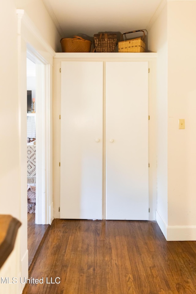 interior space with dark hardwood / wood-style flooring, crown molding, and a closet