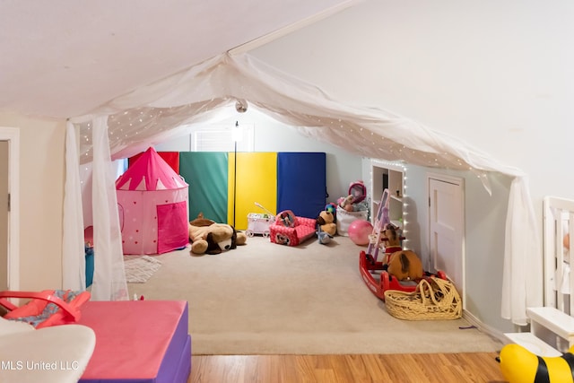 game room featuring hardwood / wood-style floors and vaulted ceiling