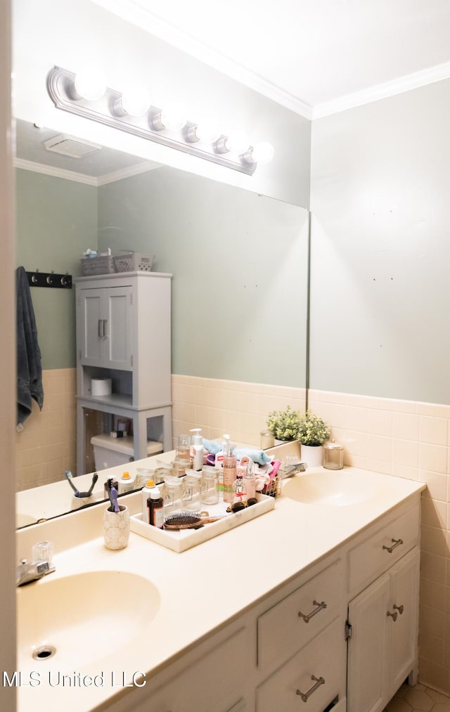 bathroom with toilet, vanity, tile walls, and ornamental molding