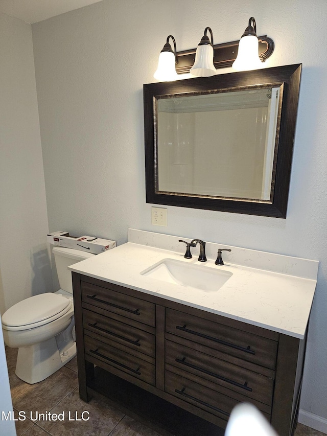 bathroom featuring vanity, tile patterned floors, and toilet