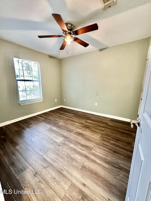 909 Orange St, Ocean Springs, MS 39564 - unfurnished room featuring a ceiling fan, dark wood-type flooring, and baseboards