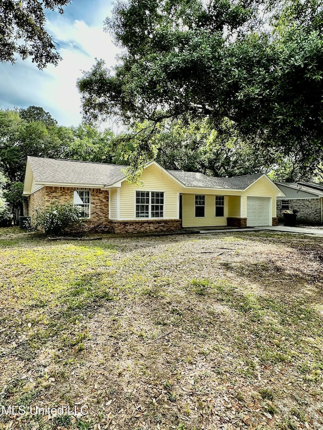 909 Orange St, Ocean Springs, MS 39564 - ranch-style house featuring a garage, brick siding, driveway, and roof with shingles