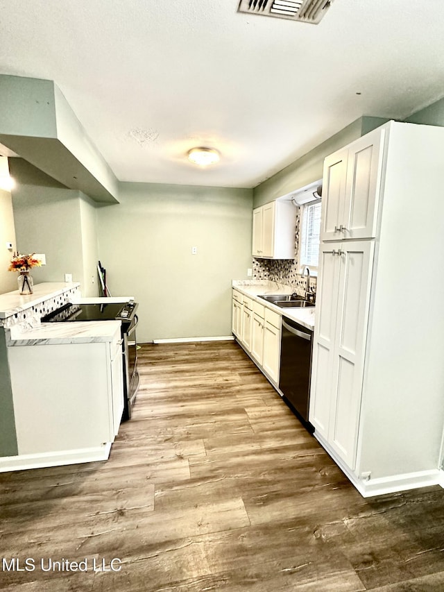 909 Orange St, Ocean Springs, MS 39564 - kitchen featuring stainless steel appliances, a sink, wood finished floors, decorative backsplash, and baseboards
