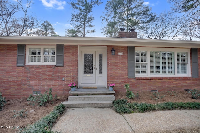 2123 Southwood Rd, Jackson, MS 39211 - view of exterior entry featuring crawl space, a chimney, and brick siding