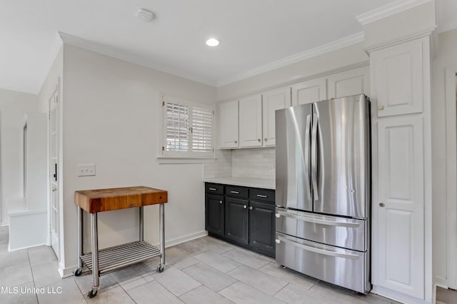 2123 Southwood Rd, Jackson, MS 39211 - kitchen with freestanding refrigerator, white cabinets, light tile patterned floors, ornamental molding, and light countertops