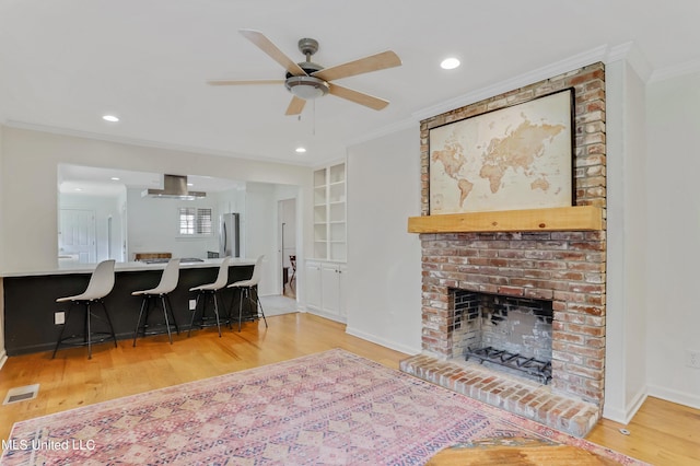 2123 Southwood Rd, Jackson, MS 39211 - living area featuring ornamental molding, ceiling fan, light wood-style floors, a fireplace, and baseboards
