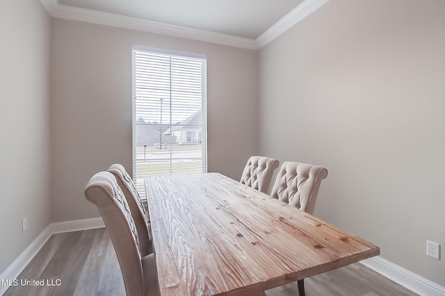 dining space featuring hardwood / wood-style floors and ornamental molding