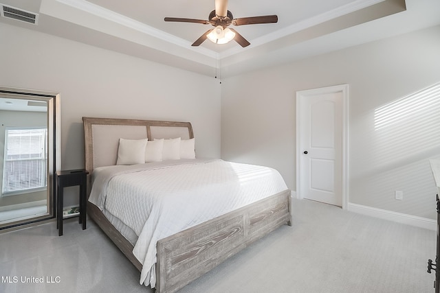 bedroom with ceiling fan, a raised ceiling, light colored carpet, and ornamental molding