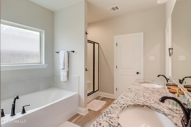 bathroom with hardwood / wood-style floors, vanity, and separate shower and tub