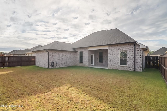 back of property with a patio area and a yard