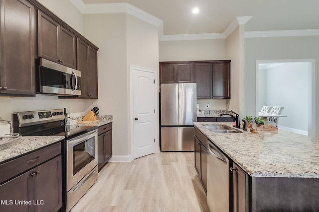 kitchen with dark brown cabinetry, sink, light hardwood / wood-style floors, appliances with stainless steel finishes, and ornamental molding