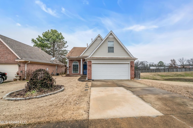 view of front of property with a garage, brick siding, driveway, and fence