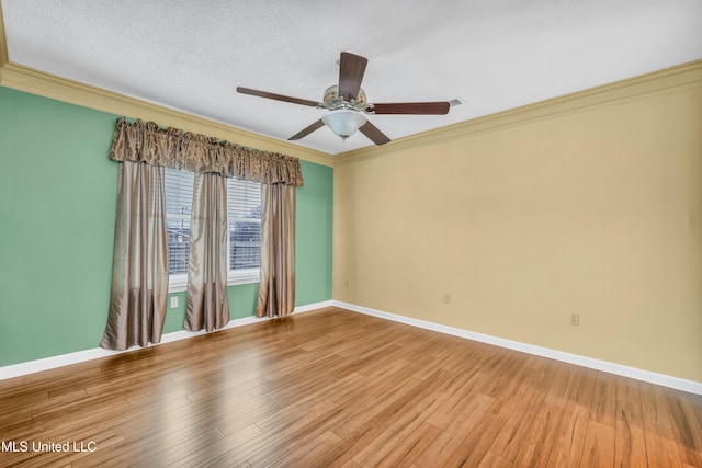 unfurnished room featuring light wood finished floors, a textured ceiling, baseboards, and crown molding