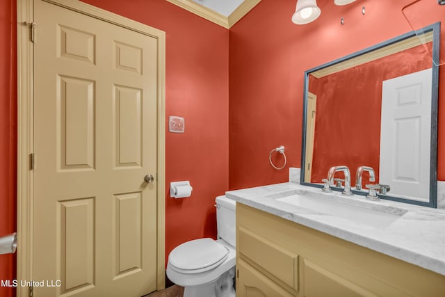 half bath featuring crown molding, vanity, and toilet