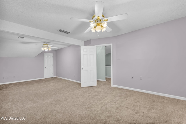 unfurnished bedroom featuring a textured ceiling, carpet, visible vents, and baseboards