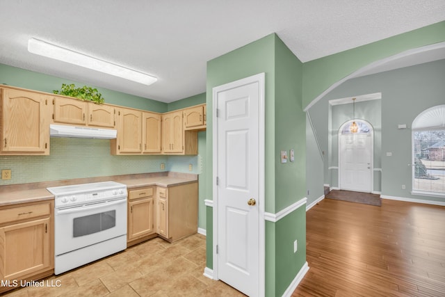 kitchen featuring light brown cabinets, under cabinet range hood, electric stove, light countertops, and backsplash