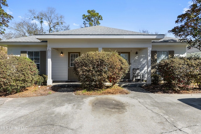 view of front of home featuring covered porch and a shingled roof