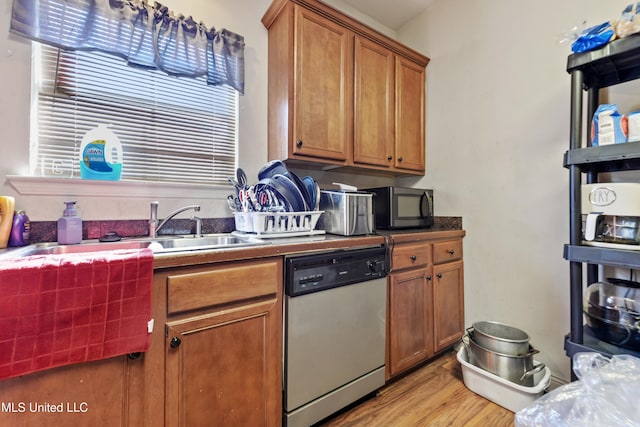 kitchen with dishwasher, light wood finished floors, a sink, and brown cabinets