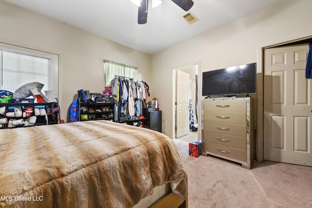 bedroom with ceiling fan, visible vents, and light colored carpet