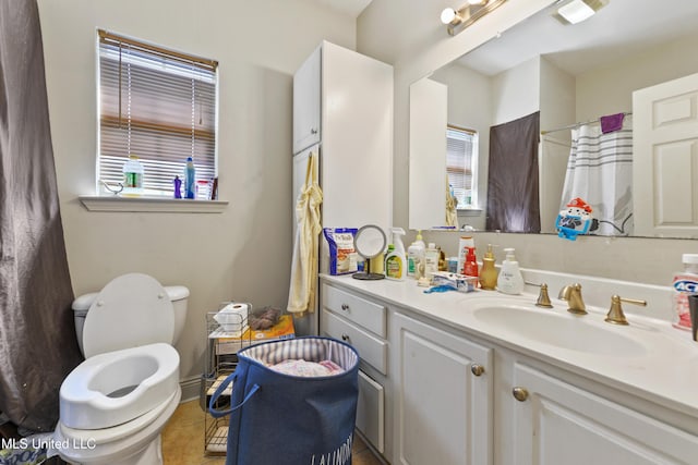 full bathroom with toilet, a healthy amount of sunlight, a shower with curtain, and vanity