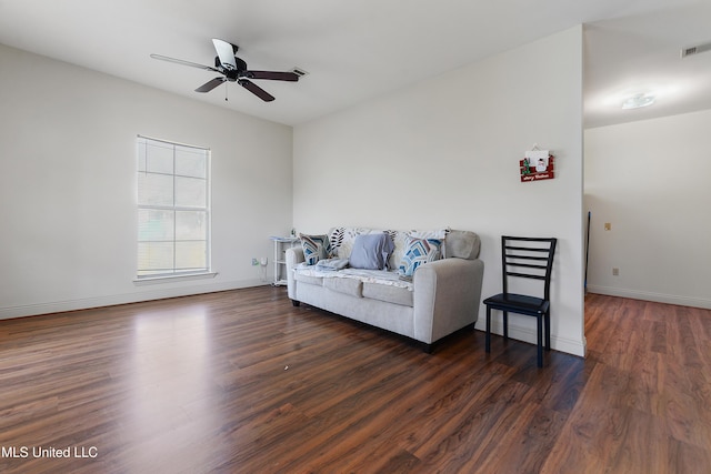 living room with a ceiling fan, baseboards, and wood finished floors