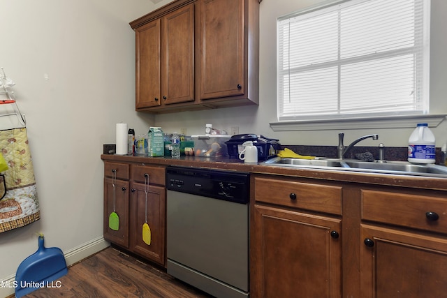 kitchen featuring a sink, stainless steel dishwasher, brown cabinets, dark wood-style floors, and dark countertops