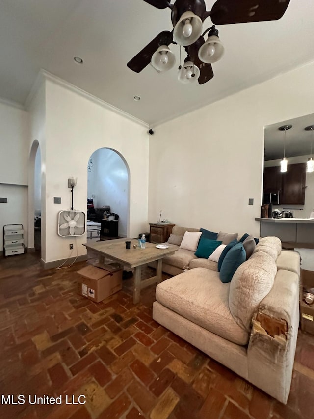 living room with ornamental molding and ceiling fan