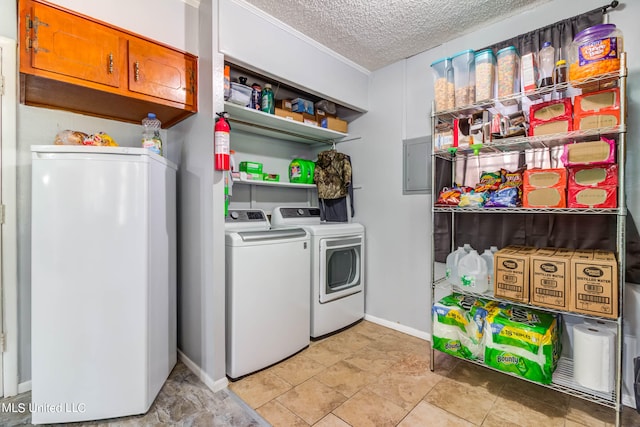 clothes washing area with light tile patterned flooring, cabinets, washer and clothes dryer, electric panel, and a textured ceiling