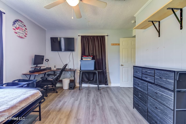 bedroom featuring ceiling fan, light wood-type flooring, and a textured ceiling