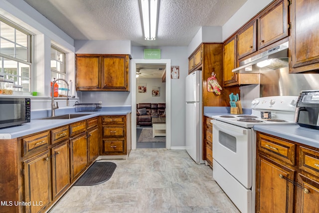 kitchen with ceiling fan, white appliances, sink, and a textured ceiling