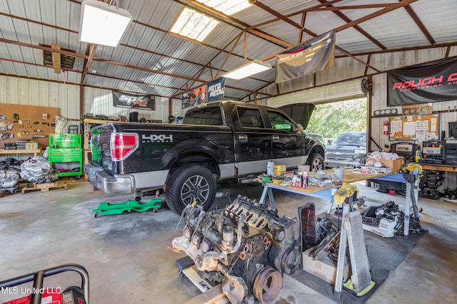 garage featuring a workshop area and wood walls