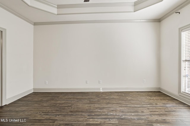 empty room featuring a raised ceiling, crown molding, and dark hardwood / wood-style floors