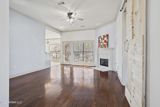 unfurnished living room with ornamental molding, a brick fireplace, wood-type flooring, and ceiling fan with notable chandelier