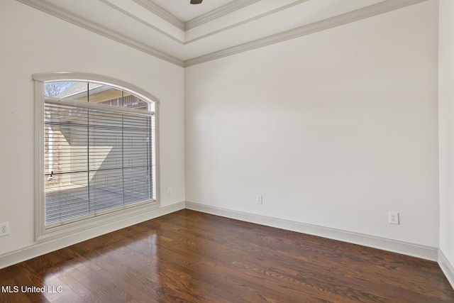 spare room with a raised ceiling, ornamental molding, and dark hardwood / wood-style flooring