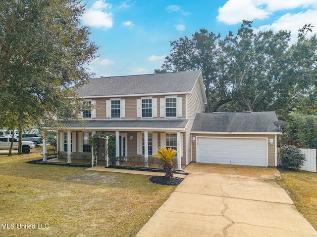 view of front of house with a garage, a front yard, and covered porch