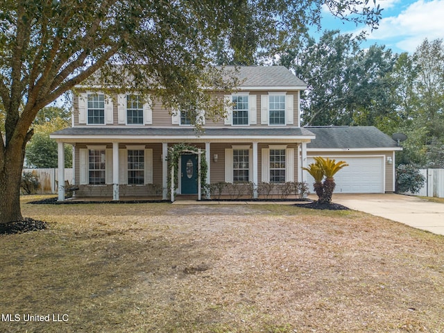 colonial inspired home with a porch, a garage, and a front lawn