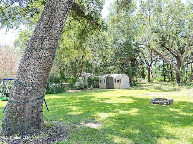 7809 Clamshell Ave, Ocean Springs, MS 39564 - view of green lawn with a storage shed and an outdoor fire pit
